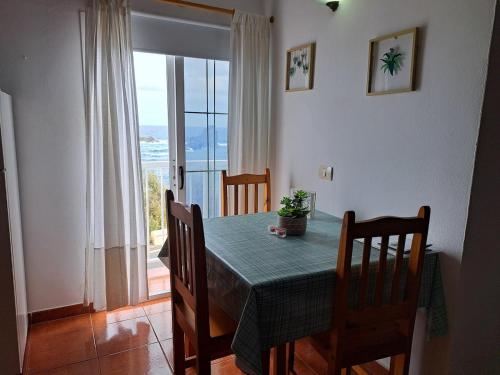 a dining room with a table and chairs and a window at Apartamento junto al mar La Baja in Santa Cruz de Tenerife