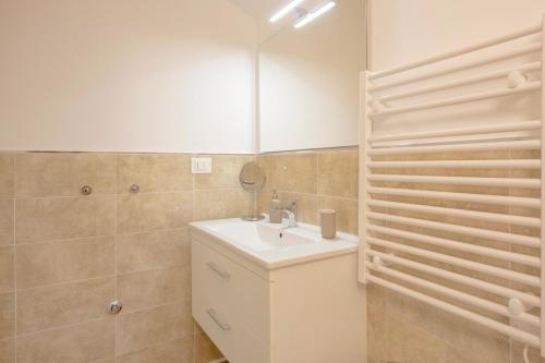 a bathroom with a sink and a mirror at Pellicano Suite Apartment in Marina di Grosseto