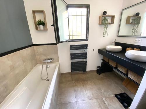 une salle de bain avec une baignoire et un lavabo dans l'établissement La Marjolaine Villa avec piscine, à La Ciotat