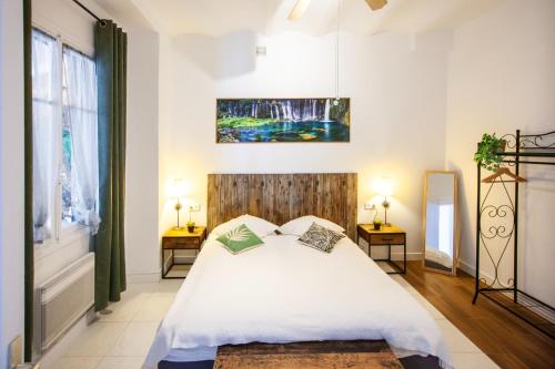 - une chambre dotée d'un lit blanc avec deux tables et deux lampes dans l'établissement Cap de Nice, à Nice