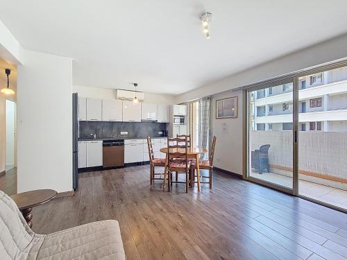 une cuisine et une salle à manger avec une table et des chaises dans l'établissement Cosy appartement 4 personnes, à Saint-Laurent-du-Var