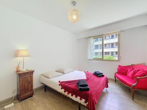 une chambre avec un lit, un canapé et une fenêtre dans l'établissement Cosy appartement 4 personnes, à Saint-Laurent-du-Var