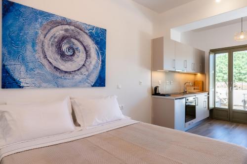 a bedroom with a bed and a painting on the wall at Apeiron Blue Perissa Apartments in Perissa