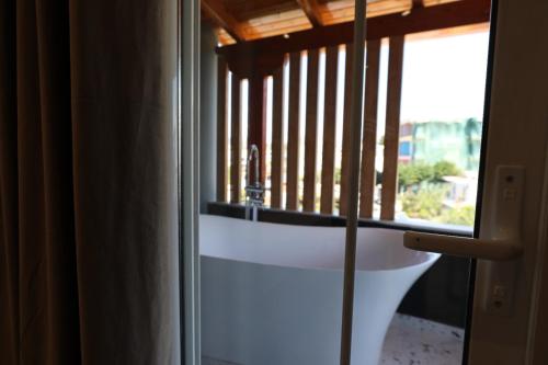 a bathroom with a window and a bath tub at Hotel Golden Oak in Ksamil