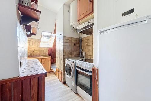 Il comprend une cuisine équipée d'une cuisinière et d'un lave-linge/sèche-linge. dans l'établissement Charming apartment near Grands Boulevards, à Paris