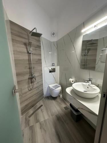 ein Badezimmer mit Waschbecken und Toilette in der Unterkunft Mirto Beach Hotel & Restaurant in Paralia Vrachou