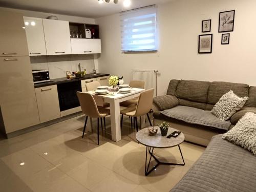 a living room with a table and a couch and a kitchen at Apartments Dani in Postojna