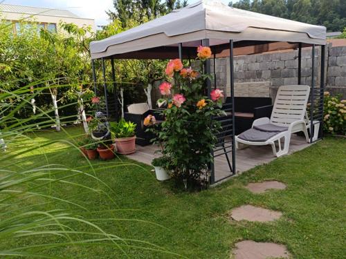 a patio with a umbrella and a chair and flowers at Apartments Dani in Postojna