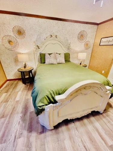 a bedroom with a large bed with green sheets at Mark House in Hammond