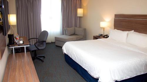 a hotel room with a bed and a chair at Holiday Inn Express Culiacan by IHG in Culiacán