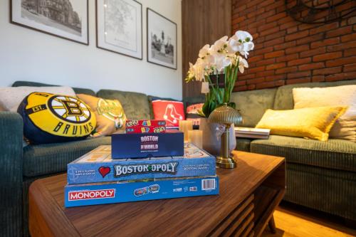 a stack of books on a coffee table in a living room at 2BR2Bth 2 Parking Spaces,TD Garden,MIT,Harvard,BOS in Somerville