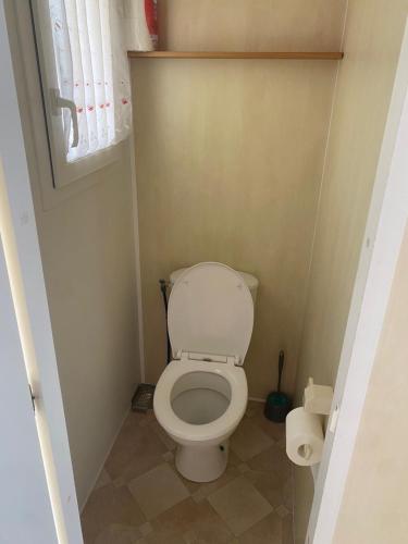 ein kleines Badezimmer mit Toilette und Fenster in der Unterkunft Location Mobil-home - Vacances près de la mer in Carnac