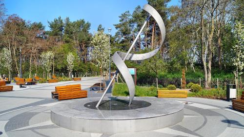 a large metal sculpture in a park with benches at Apartament Familia Dziwnówek in Dziwnówek