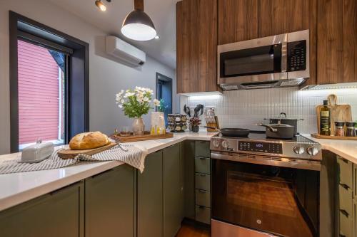 a kitchen with a stove and a microwave at 2BR2Bth 2 Parking Spaces,TD Garden,MIT,Harvard,BOS in Somerville
