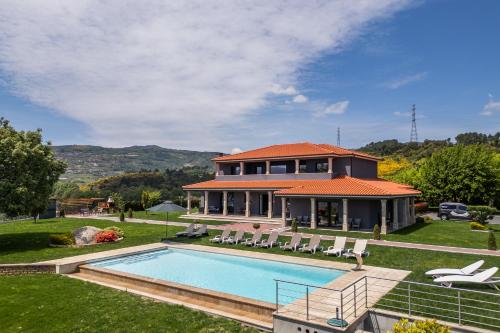 a house with a swimming pool in front of a house at Ladeira Suites, a Douro Retreat by HostWise in Santa Marinha do Zêzere
