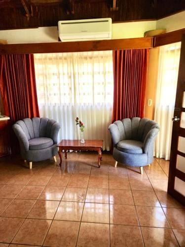 two chairs and a table in a living room at Hotel Villa Acacia in Playa Hermosa