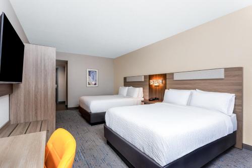 a hotel room with two beds and a flat screen tv at Holiday Inn Express & Suites Palm Coast - I-95 in Palm Coast