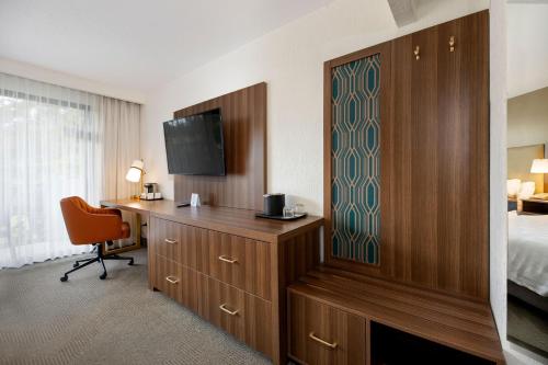 a hotel room with a bed and a desk with a television at Holiday Inn San Jose La Sabana by IHG in San José