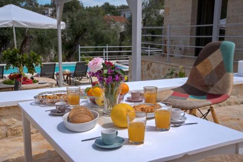 a table with breakfast foods and orange juice on it at Villa Rei 3 Bedroom Villa with Pool in Vlachopoulátika