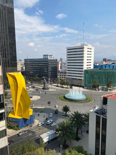 a view of a city with a yellow building and a fountain at PENTHOUSE gran vista, maravillosa ubicación in Mexico City