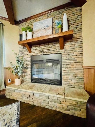 a living room with a stone fireplace with shelves at Mark House in Hammond