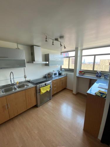 a large kitchen with a sink and a stove at PENTHOUSE gran vista, maravillosa ubicación in Mexico City
