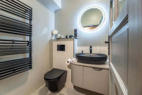 a bathroom with a black sink and a toilet at Apartmány Plavy in Plavy