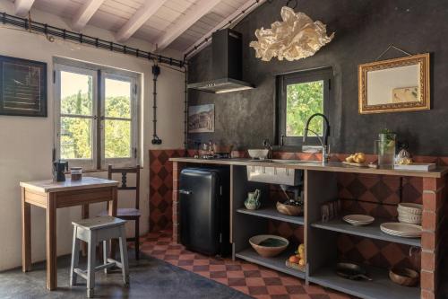 a kitchen with a black refrigerator and a table at CABRA - Porto Covo in Porto Covo