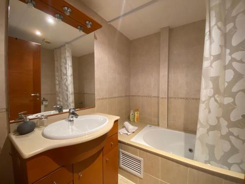 a bathroom with a sink and a bath tub at Reconnectar Blanes Montserrat in Blanes