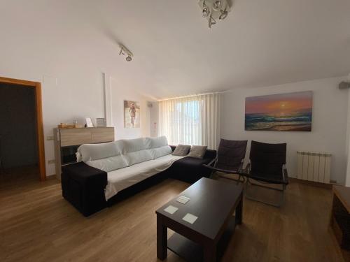 a living room with a couch and a table at Reconnectar Blanes Montserrat in Blanes