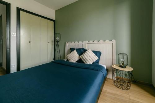 - une chambre avec un lit avec des draps bleus et une table dans l'établissement Spacieux T3 en centre avec garage clos - calme et tout confort, à Rodez