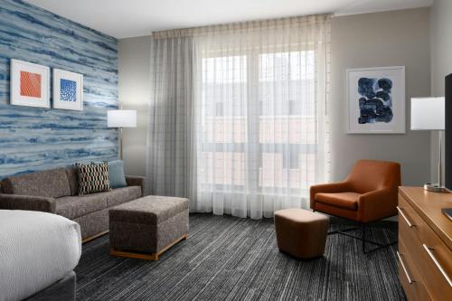 a living room with a couch and a chair at TownePlace Suites by Marriott Champaign in Champaign