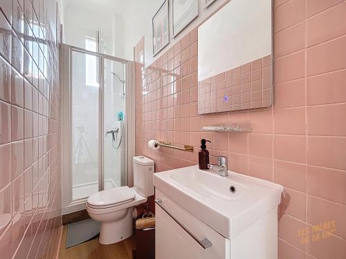 une salle de bains rose avec lavabo et toilettes. dans l'établissement Appartement Rénové - Stade Vélodrome & Plages - Les Frères de la Loc', à Marseille