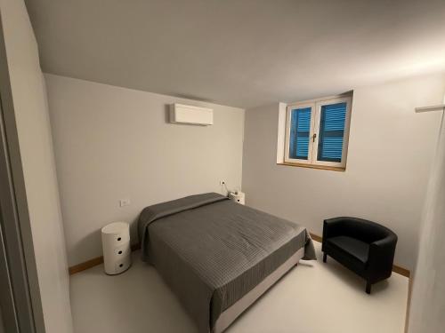 a bedroom with a bed and a black chair at Alessandra House in Grottammare