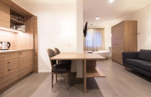 a kitchen and living room with a wooden table and chairs at Apartments Sissi & Franz in Merano