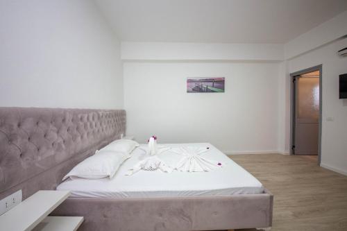 a bedroom with a large bed with white sheets and pillows at 2E Villa & Homestay in Ksamil