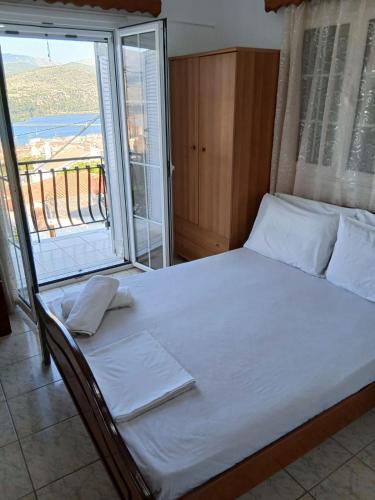 a bed in a room with a large window at ELENA SEAVIEW house in Argostoli