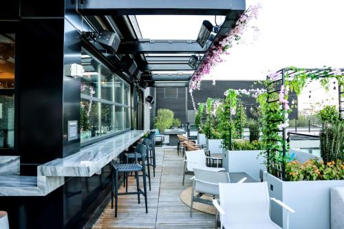 a restaurant with a bar with white chairs and plants at Washington Marriott Capitol Hill in Washington
