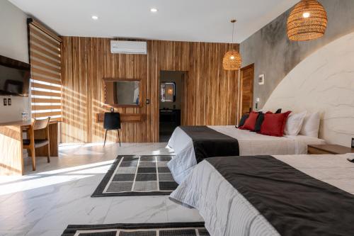 a hotel room with two beds and a desk at La Cascada Hotel Boutique in Juanacatlán