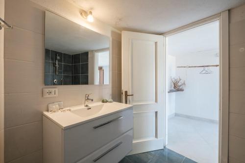 a bathroom with a sink and a mirror and a shower at Discesa a mare - Lussuosa Villa a 180 sul Mare in Villaggio Piras