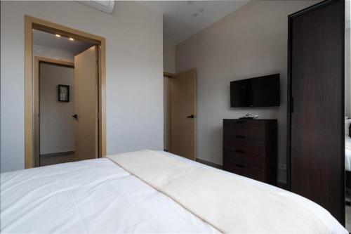 a bedroom with a bed and a flat screen tv at Breakfast included - 2 bedrooms - RL1 707 in La Julia