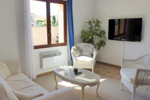 - un salon avec une table, des chaises et une télévision dans l'établissement Beautiful family house with pool, à Six-Fours-les-Plages