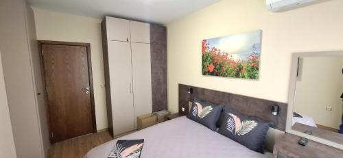 Un dormitorio con una cama y un cuadro en la pared. en Byala Vista A-54, en Byala
