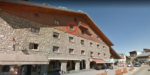 un grand bâtiment en brique arborant un drapeau américain. dans l'établissement Studio refait à neuf au cœur du village, à Péone