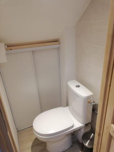 une salle de bain avec des toilettes blanches dans une chambre dans l'établissement Studio refait à neuf au cœur du village, à Péone