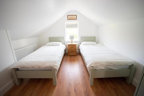 two twin beds in a room with a window at The Swilly Suite in Castlequarter