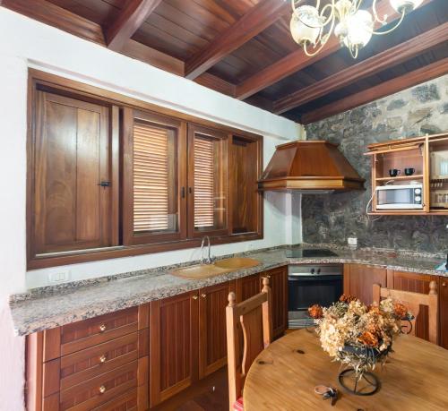 a kitchen with wooden cabinets and a wooden table at Casas Rurales La Tanquera y Las Rosas in Los Realejos