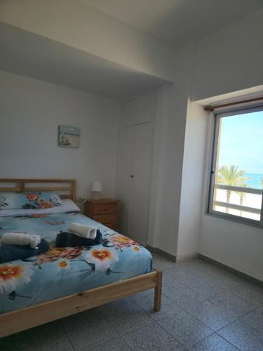 a bedroom with two beds and a window with the ocean at Beach view apartment in Cullera in Cullera