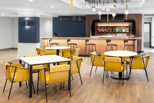 a restaurant with tables and chairs and a bar at Courtyard Cleveland Airport South in Middleburg Heights