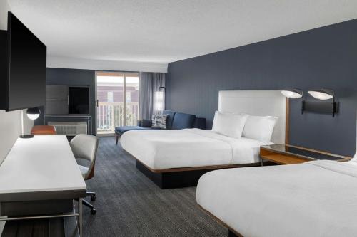 a hotel room with two beds and a desk at Courtyard Cleveland Airport South in Middleburg Heights
